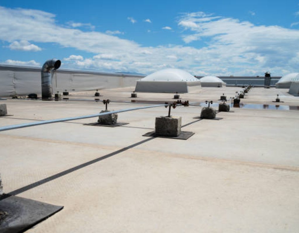 Commercial Roofing in Hamilton, NJ underway as a crew checks membrane seams near rooftop units