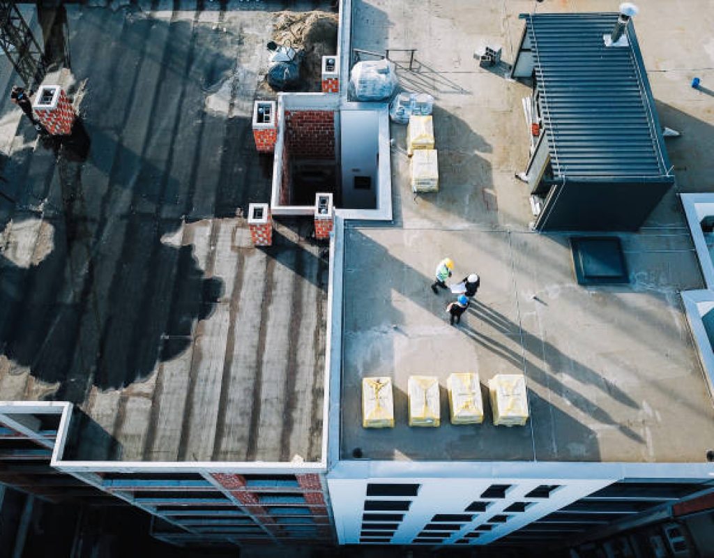 Commercial Roofing in Atlantic City - NJ underway as a crew inspects seams on a flat roof